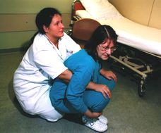 Durch Vorwärtsbewegung und Druck auf die Knie die Pat. in Hockstellung bringen